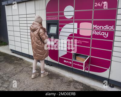 Loriol sur Drome, Frankreich - 14. Januar 2023: Abholung eines Pakets aus einem Mondial`Relay-Schließfach durch eine junge Frau. Schließfächer Mondial Relay. Pickup-Box. Stockfoto